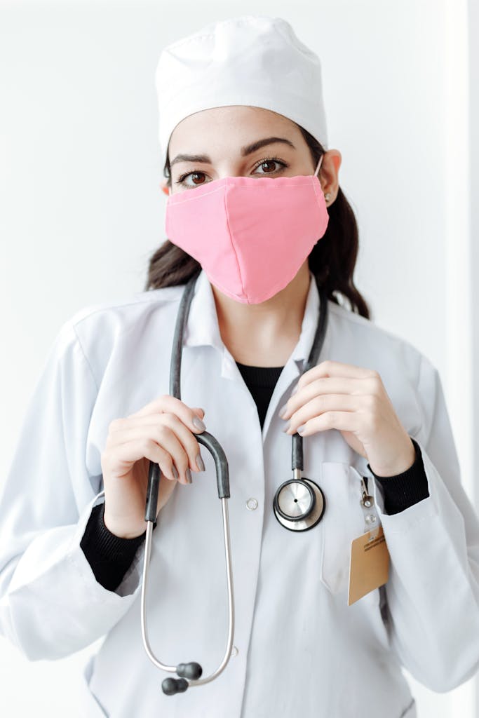 A doctor wearing a pink face mask and a stethoscope, symbolizing health and protection.